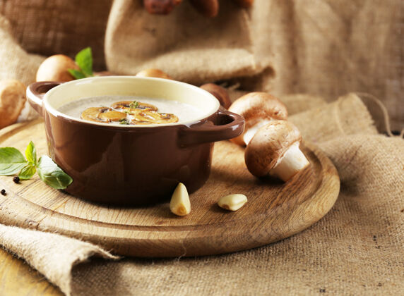 蘑菇用蘑菇汤在锅里 新鲜和干燥的蘑菇 在木桌上 在麻布上组成切片奶油锅