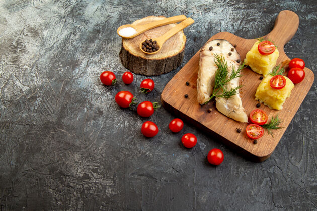 健康水煮鱼荞麦饭的正面图 上面放着西红柿 绿色奶酪 木制砧板 冰面上的香料奶酪午餐胡椒