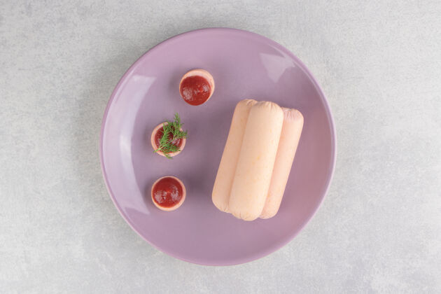 小吃紫色盘子上煮的自制香肠和番茄酱香肠肉板