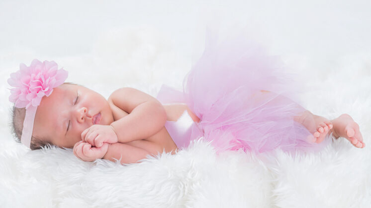 可爱新生儿戴着粉红色的花冠新生儿宝贝美丽
