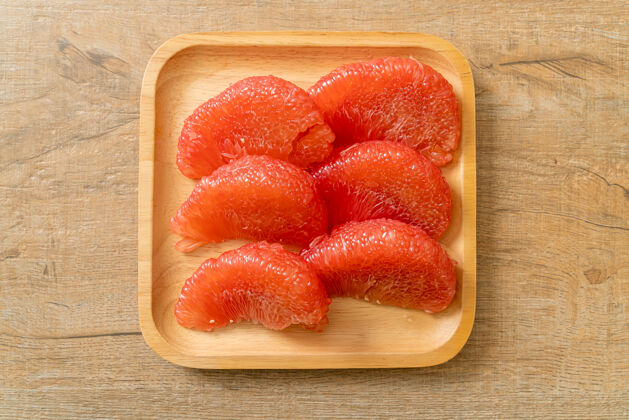 叶子盘子里有新鲜的红柚子或葡萄柚美味葡萄柚水果
