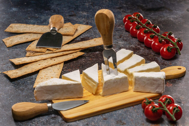 帕尔马干酪切碎布里干酪放在砧板上 旁边是西红柿和扁平面包美食香草牛奶