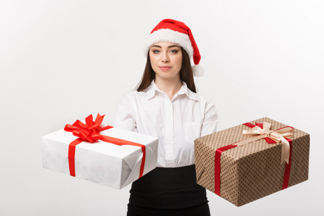 花式圣诞概念年轻快乐的高加索女商人与圣诞老人帽子赠送一个选择的礼品盒与复制空间的一面概念圣诞节礼物