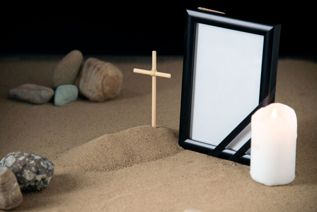 蜡烛带石头的小坟墓的正面图 相框和蜡烛空空白框架