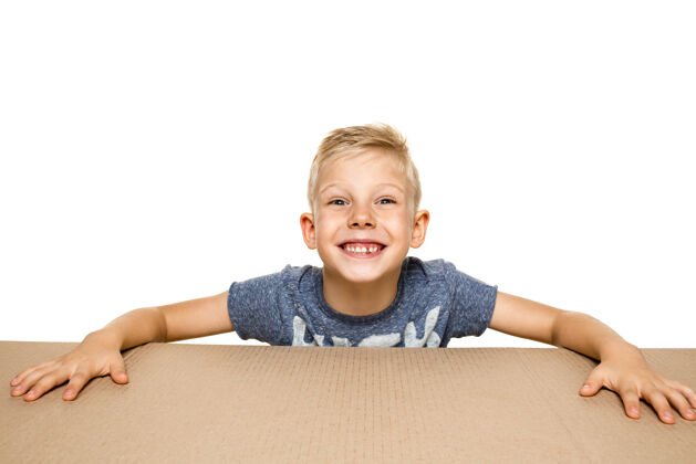 包装可爱 惊讶的小男孩打开最大的包裹震惊 快乐的年轻男模在纸板箱上小服务男孩
