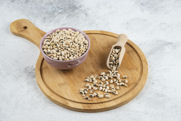 谷物一碗白芸豆 用勺子放在砧板上食物生的碗
