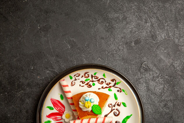 内部俯瞰美味的奶油派甜甜的蛋糕片在设计好的盘子里放在深色的桌子上蛋糕派颜色甜甜的饼干奶油容器圆圈磁盘