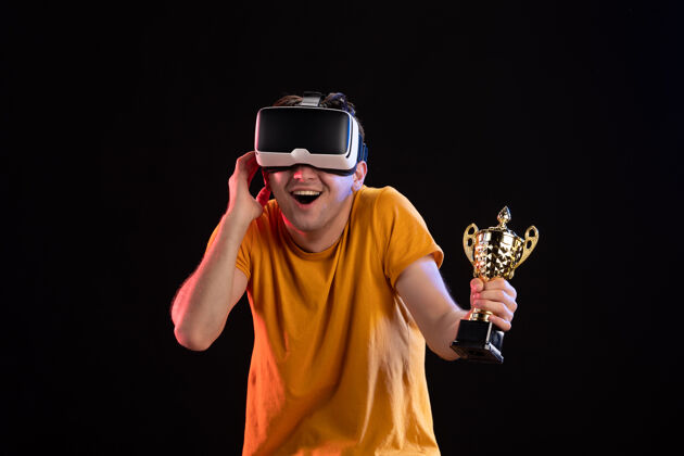 肖像年轻人的肖像玩虚拟现实与冠军杯黑暗的墙壁男赢家虚拟现实
