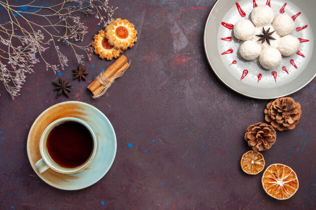 食物俯瞰美味的椰子糖小而圆 用茶杯在深色背景上形成椰子糖茶甜饼饼干圆杯子茶