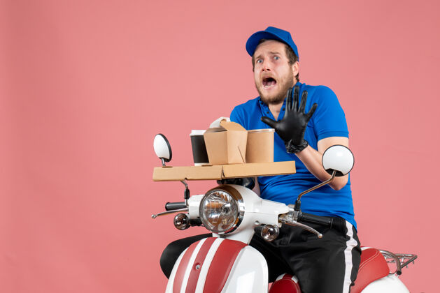 工作正面图身穿蓝色制服的男快递员手持咖啡和食品盒 骑着粉色服务快餐车工作高尔夫盒子快餐