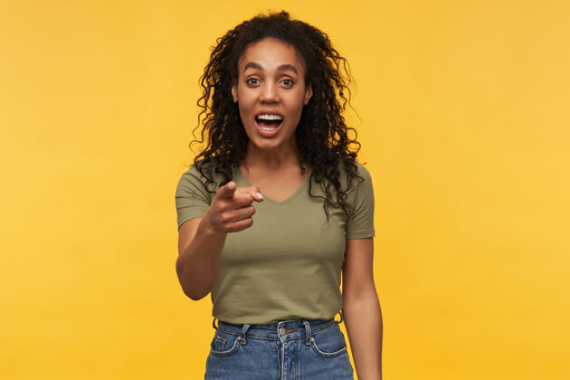 女人开朗积极的非裔美国女性 穿着绿色t恤和牛仔裤 笑着用手指着你女士大笑黑发