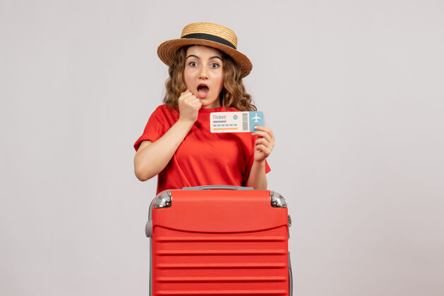 帽子带着红色旅行袋拿着票的惊喜度假女人票欢呼可爱