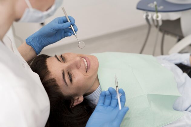 雇员在牙医那里做手术的女病人乳胶手套妇女过程