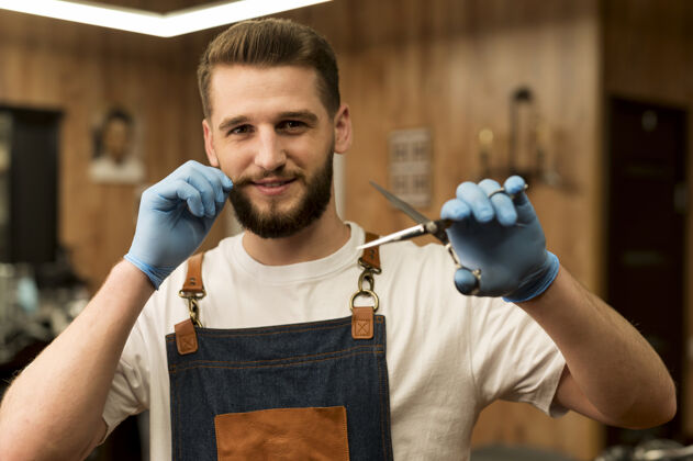 男性男理发师持剪刀在理发店的正面图职业职业就业