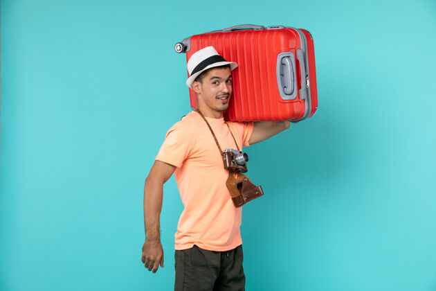 红色带着红色手提箱和蓝色相机的度假男人旅程航行人