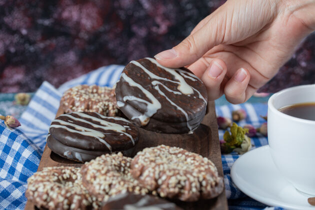 美味巧克力和椰子饼干放在木板上 配上一杯茶烹饪美味糕点