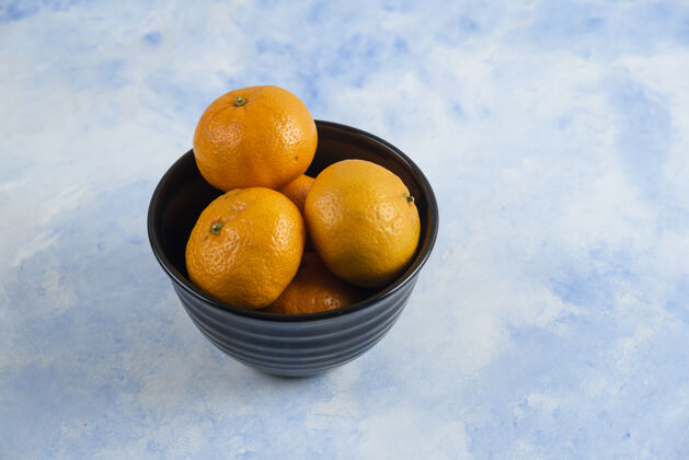美味黑碗里的克莱门汀·曼达林特写镜头营养食物柑橘
