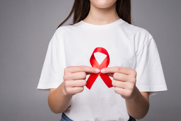 世界世界乳腺癌日的概念 保健-妇女穿白色t恤与粉红丝带的认识 象征性的蝴蝶结颜色提高人们对妇女乳腺肿瘤疾病的生活护理手艾滋病