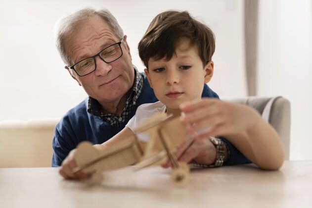 孩子小男孩在和爷爷玩世代飞机水平