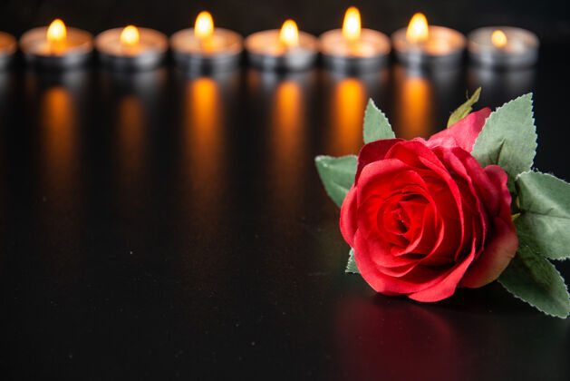 记忆燃烧的蜡烛作为一个黑色的表面下降记忆的正面视图死亡倒下花
