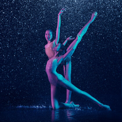 赤脚两个年轻的女芭蕾舞演员在水滴下身体女孩人