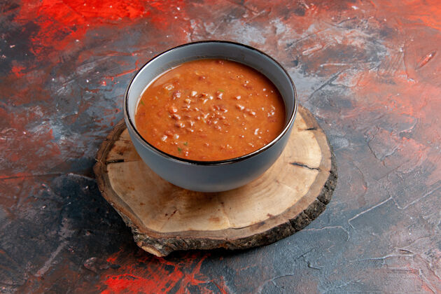 美味混合色桌子上棕色木制托盘上蓝色碗中番茄汤的俯视图桌子蔬菜健康