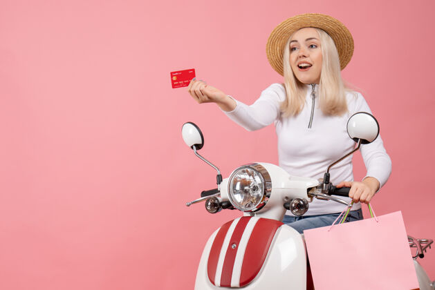 自行车前视图：骑着轻便摩托车的年轻女士拿着购物袋送卡片包车辆车身