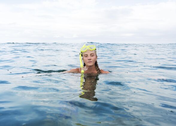 水带着潜水设备在海里游泳的女人水平游泳水下