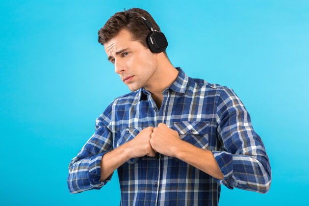 姿势坐在蓝色耳机上听音乐的男人的画像城市表情自信