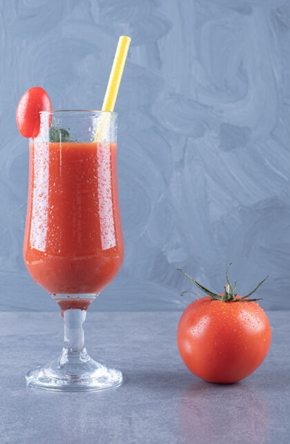 果汁一杯新鲜番茄汁和番茄在灰色背景上的垂直照片素食切割番茄