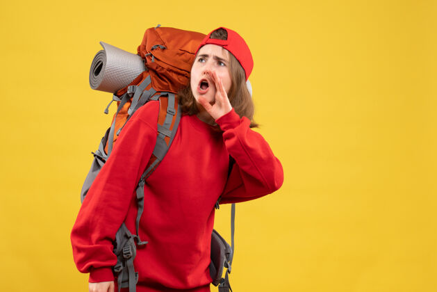 幽默正面图漂亮的女旅行者背着背包在呼唤某人前面有人背包