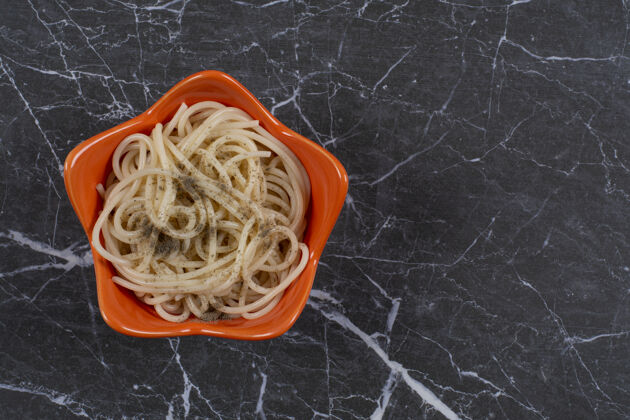 小吃新鲜的自制意大利面和香料放在橙色的碗里传统意大利面美味