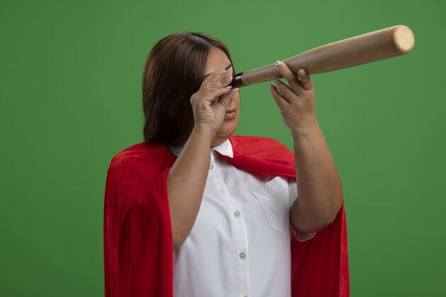 女中年女超级英雄在绿色球场上展示棒球棒的造型动作超级英雄格林手势