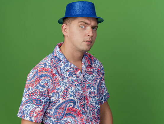 帽子可疑的年轻人戴着蓝帽子在绿色隔离党蓝色小伙子派对