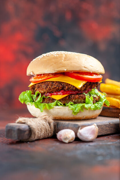 芝士汉堡前视图美味的肉汉堡与炸薯条在黑暗的背景背景生菜前面