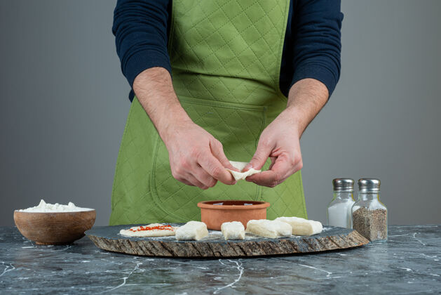 生的男性手戴手套在大理石桌上做食物手工制作自制烹饪