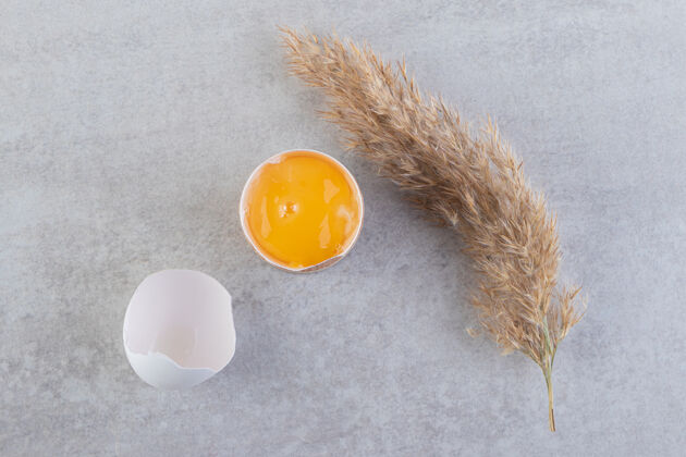 早餐石桌上放着一个蛋黄蛋鸡肉新鲜蛋壳