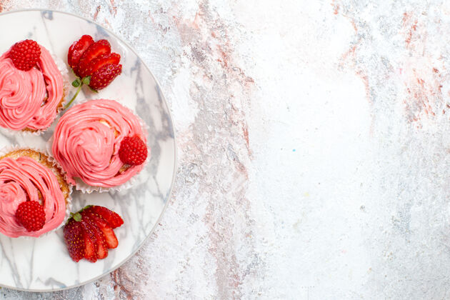 水果粉红色草莓蛋糕的顶视图 浅白色表面上有新鲜的红色草莓可食用水果草莓饼干