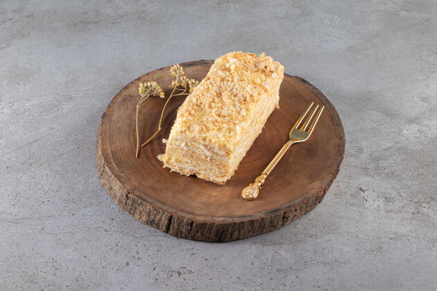 叉子把蛋糕和叉子放在大理石表面的木板上糖果美味烹饪