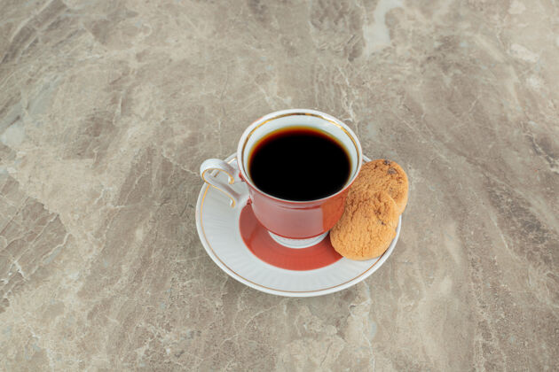 烤一杯咖啡和饼干放在大理石表面餐热糕点