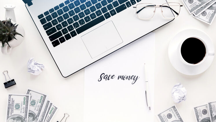 图表桌上有财务工作用品笔记本电脑 钱 咖啡 笔 纸分析财务在线
