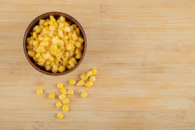 生的木桌上放着一碗爆米花籽黄色收获种子
