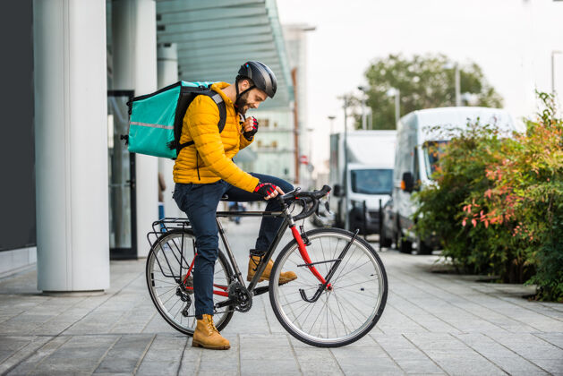 房子送菜服务 骑手用自行车送菜给客户-关于交通 送菜和技术的概念男人商务城市