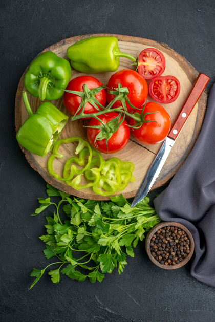 胡椒新鲜蔬菜的俯视图和刀在砧板上 绿色的花椒捆在黑色的破洞表面蔬菜食物苦恼