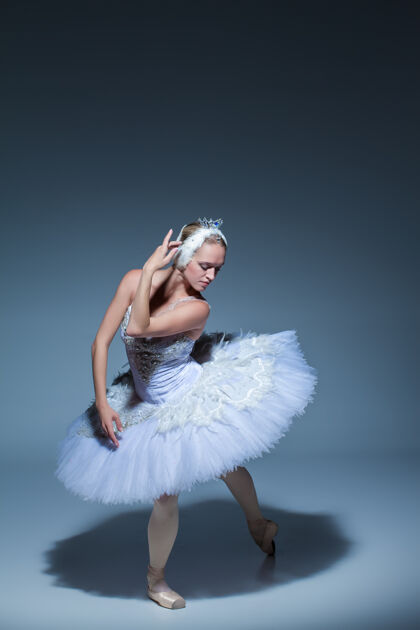 女演员芭蕾舞演员在蓝色背景下扮演白天鹅的肖像艺术家芭蕾舞女孩