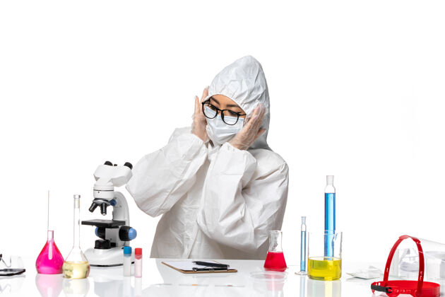实验室前视图穿着特殊防护服的女化学家在白色背景的化学病毒实验室里用不同的溶液工作医生化学视图