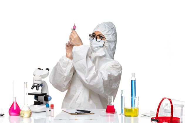 白色前视图穿着特殊防护服的女化学家在白色背景的covid化学病毒实验室工作防护注射病毒