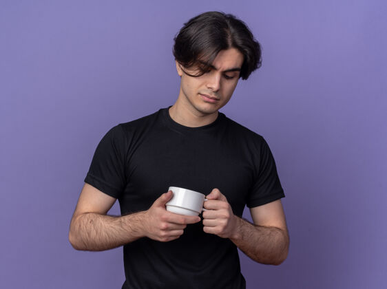 咖啡想着那个穿着黑色t恤的年轻帅哥 捧着一杯孤立在紫色墙上的咖啡看着抱着年轻小伙子