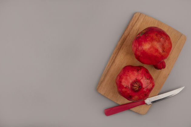 新鲜顶视图新鲜的红石榴在一个木制厨房板与刀复制空间石榴食物刀
