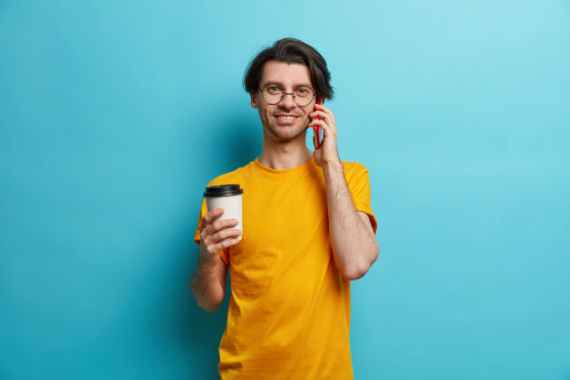 电话帅哥的照片成年欧洲男人通过智能手机打电话喝咖啡去黄色男性抱着